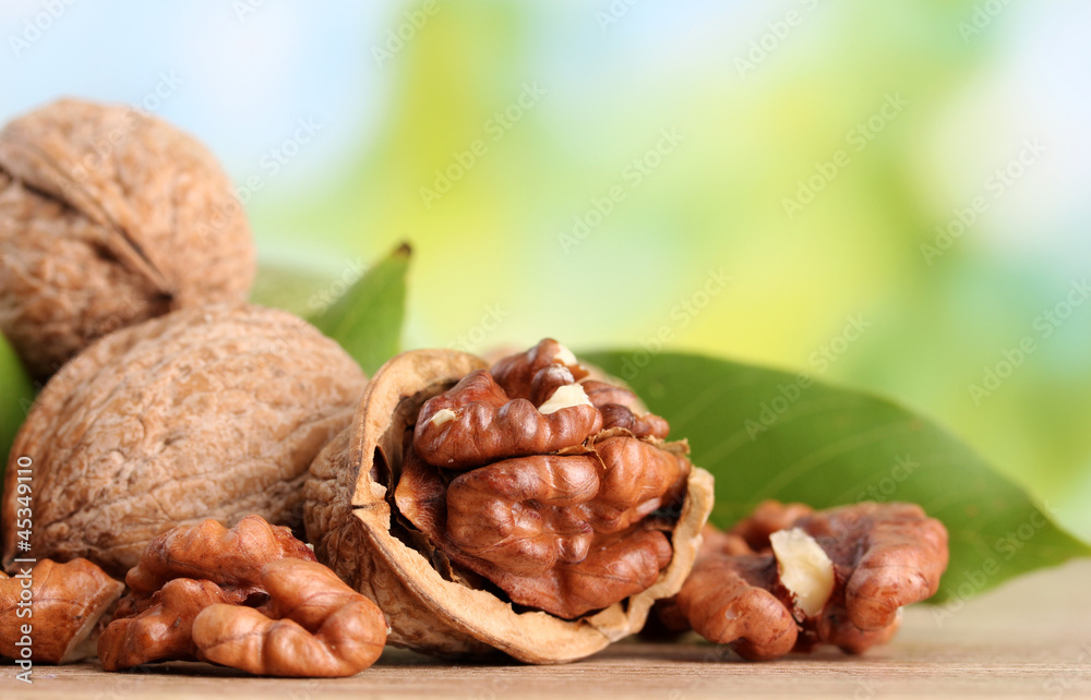 walnuts with green leaves, on green background walnuts with green leaves, on green background