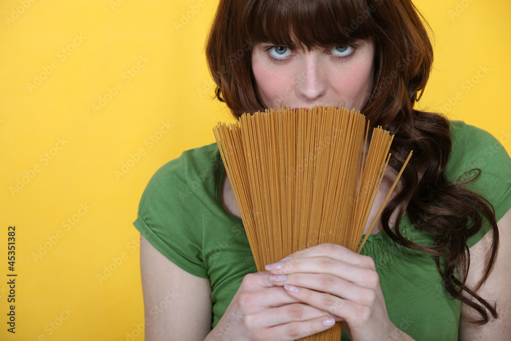 beautiful brunette holding spaghettis isolated on yellow beautiful brunette holding spaghettis isolated on yellow