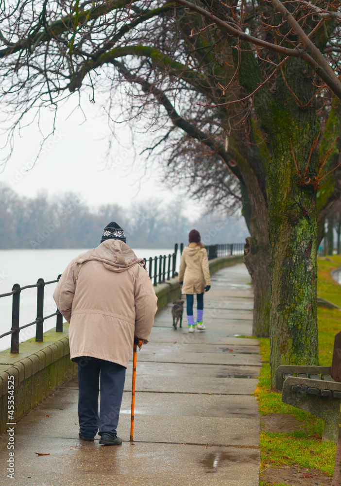 Φωτογραφία Teenage girl with dog and old man walking beside the river