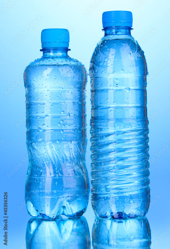 plastic bottles of water on blue background