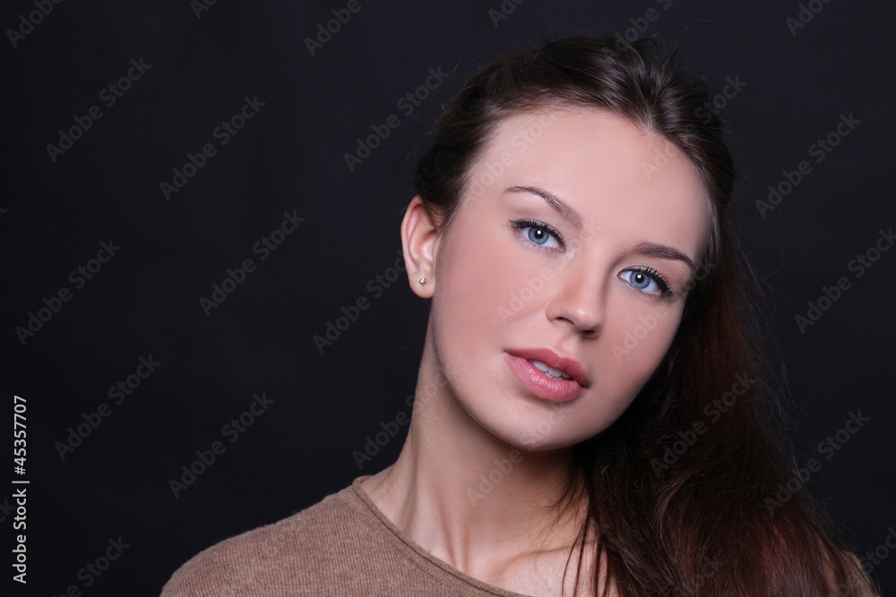 Beautiful young woman in dark background Beautiful young woman in dark background