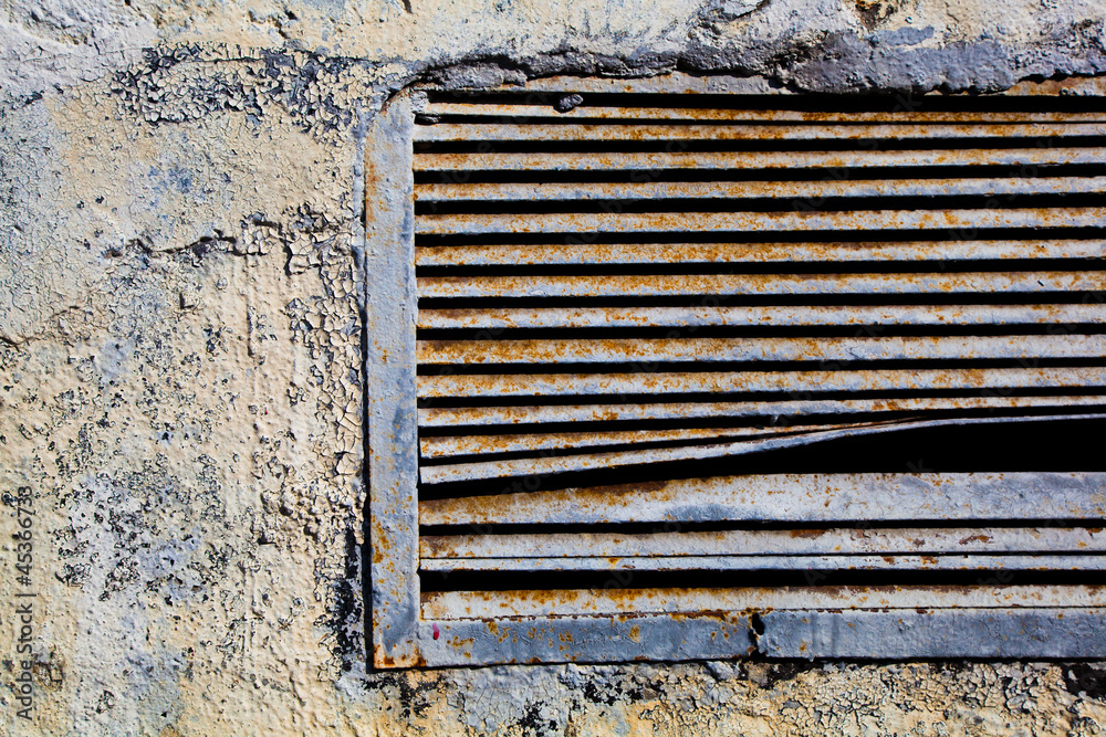 Old rusty ventilation grille Textured wall with bulging paint Old rusty ventilation grille Textured wall with bulging paint