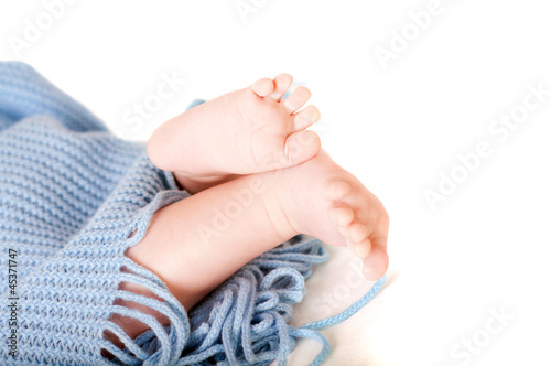 Baby feet covered in blue wrap isolated background