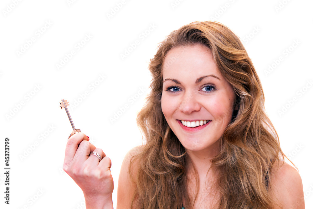 Happy young woman smiling holding a door key Happy young woman smiling holding a door key