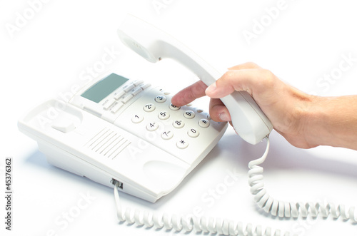 Man's hand dialing telephone keypad