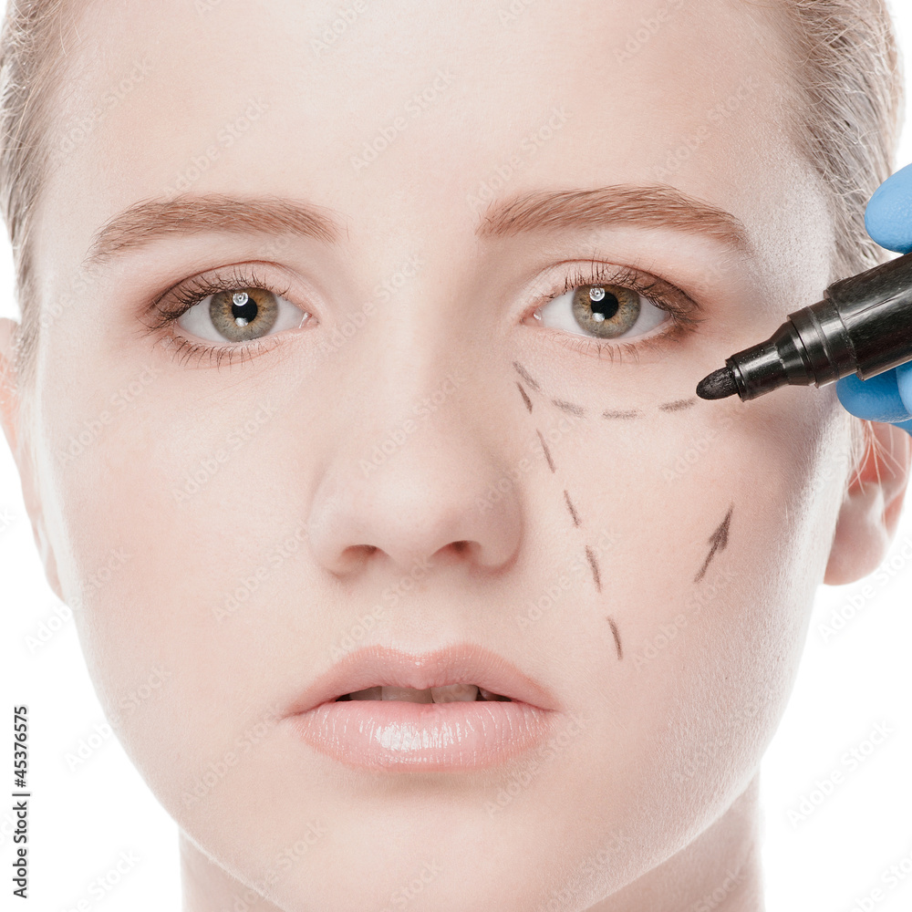 Beautician draw correction lines on woman face