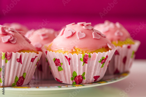Leckere glasierte Mini-Kuchen verziert mit Zuckerherzen photo