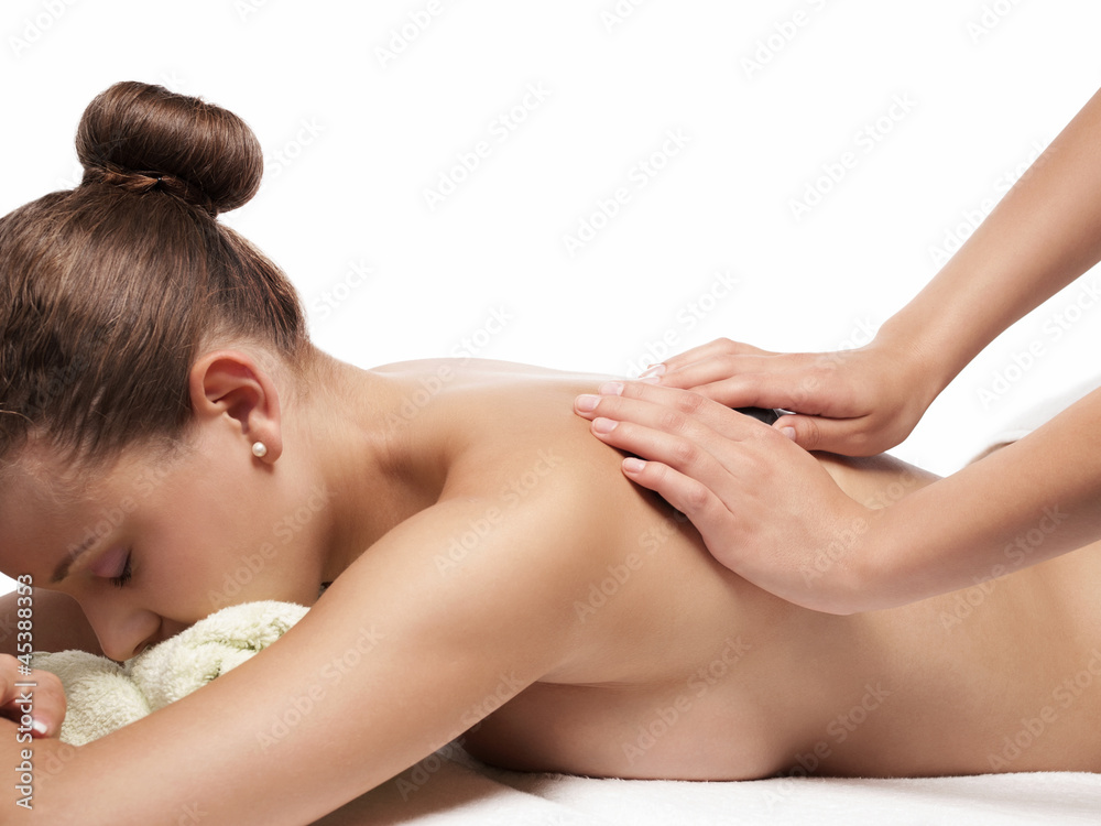 Pretty young woman receives hot stone massage - isolated Pretty young woman receives hot stone massage - isolated