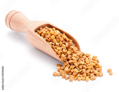 wooden scoop with fenugreek isolated on white photo