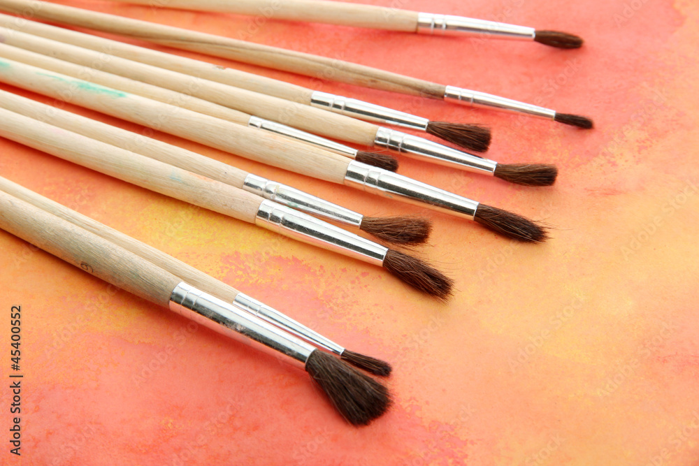 brushes on bright abstract gouache painted background brushes on bright abstract gouache painted background