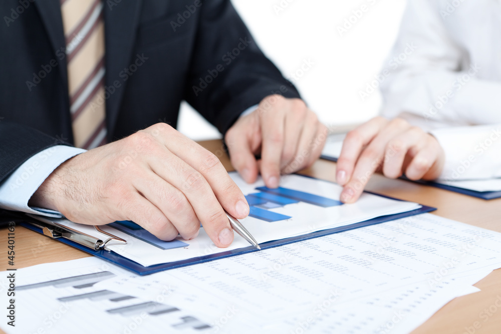 Manager working with diagrams. Close up of hands and documents Manager working with diagrams. Close up of hands and documents