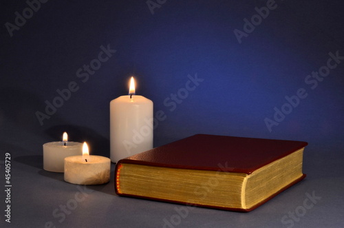 Buch mit Goldschnitt und drei Kerzen