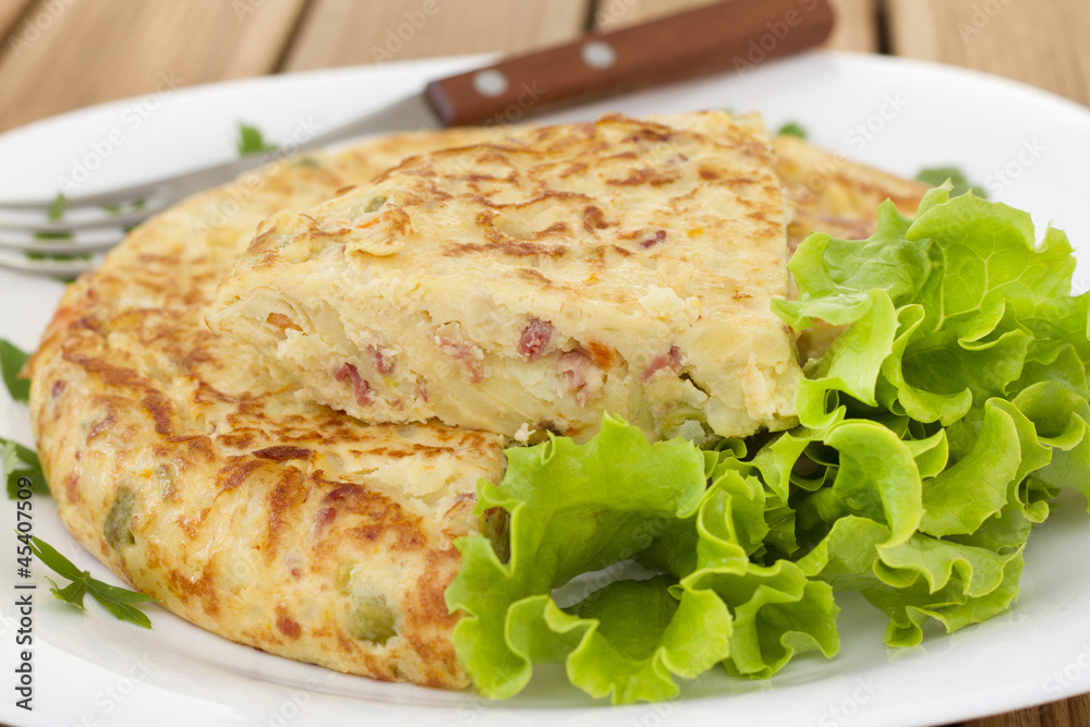 spanish omelet with lettuce on the white plate spanish omelet with lettuce on the white plate