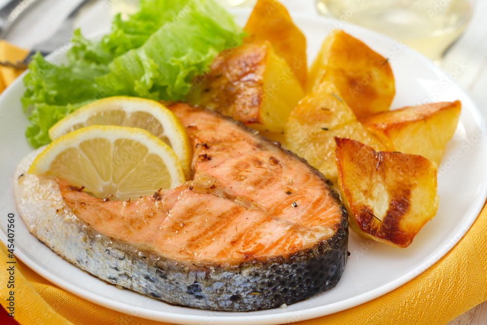 fried salmon with lemon and potato on the plate fried salmon with lemon and potato on the plate