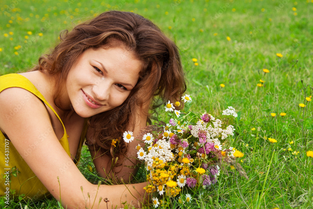 beautiful girl laying on grass with bouquet beautiful girl laying on grass with bouquet