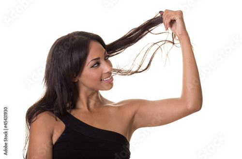 Beautiful woman examines her hair.