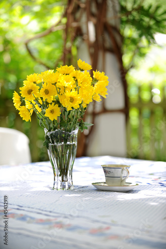 Fototapeta Naklejka Na Ścianę i Meble -  Yellow Daisies and tea Cup Outdoors