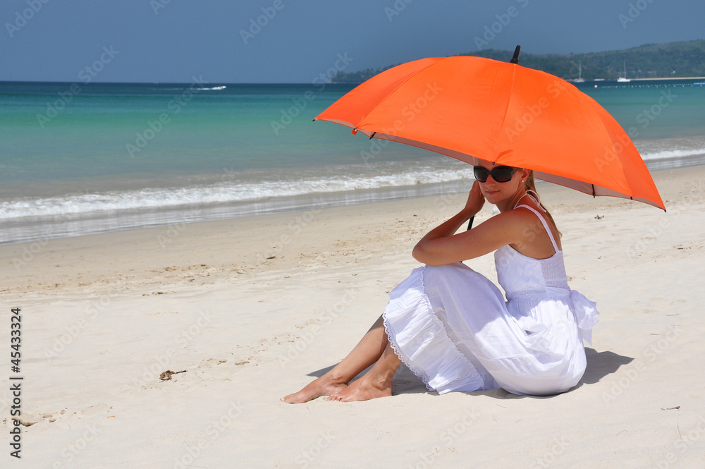 Girl with an orange umbrella on the sandy beach Girl with an orange umbrella on the sandy beach