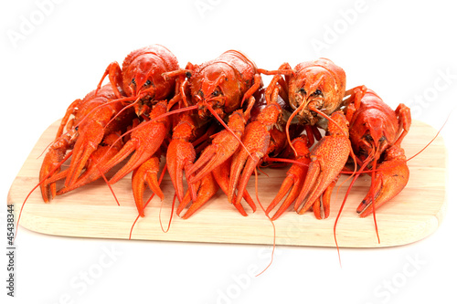 Tasty boiled crayfishes on chopping board isolated on white