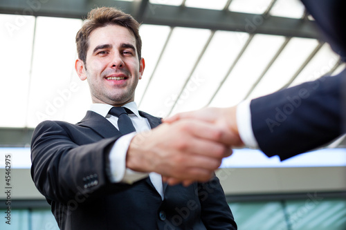 Businessman shaking hands at the office on blurred background