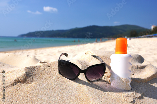 Sunglasses and lotion on the sandy beach of Phuket island, Thail