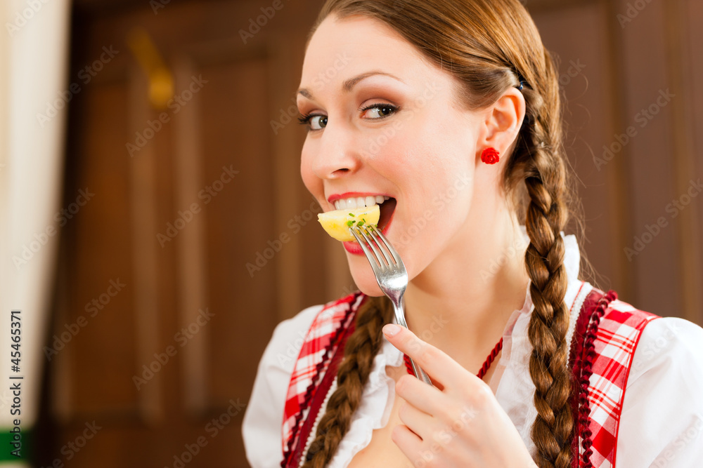 Frau in Tracht isst in Wirtschaft oder Restaurant Frau in Tracht isst in Wirtschaft oder Restaurant