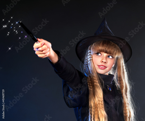 Witch girl with magic wand casting spells. © Gennadiy Poznyakov