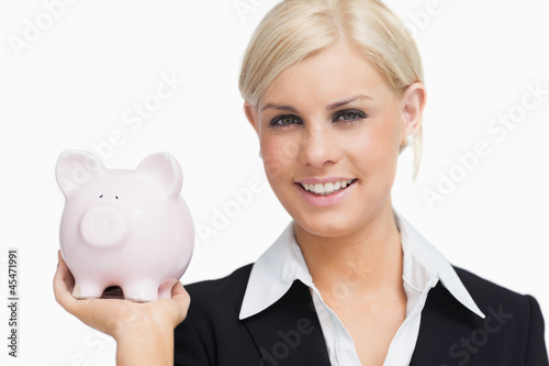 Smiling businesswoman holding a piggy-bank