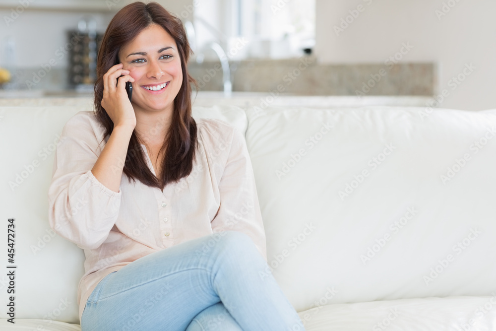 Woman phoning while sitting on the couch Woman phoning while sitting on the couch