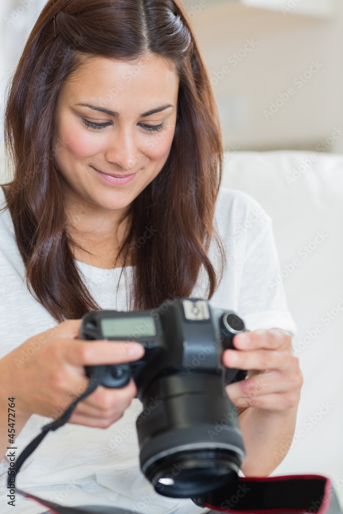Brunette viewing photos while sitting on the sofa