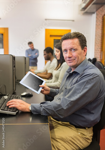Mature student in computer class holding tablet pc © WavebreakMediaMicro