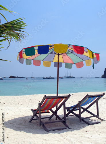 Sun chair under umbrella on a tropical sandy beach of Phi-Phi is