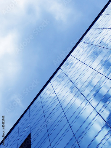 Cloudy sky reflected in the glass wall of a high-rise building