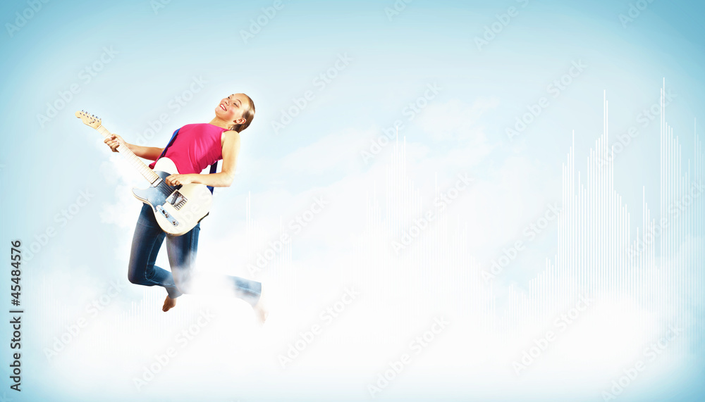 young woman playing on electro guitar and jumping young woman playing on electro guitar and jumping