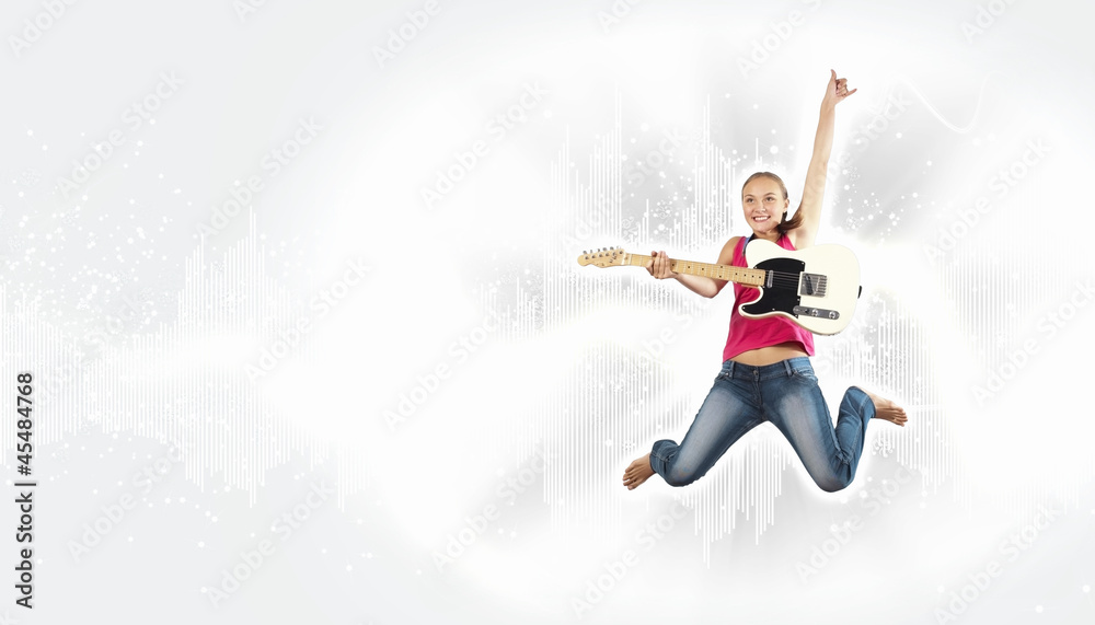 young woman playing on electro guitar and jumping young woman playing on electro guitar and jumping