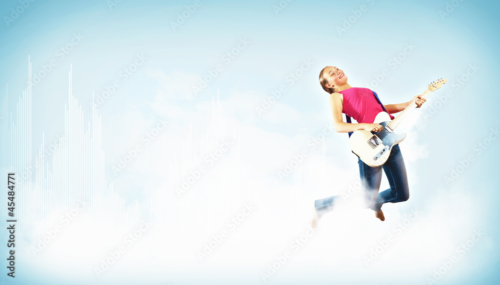young woman playing on electro guitar and jumping young woman playing on electro guitar and jumping