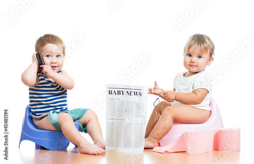 funny children with newspaper and pda on chamberpot photo