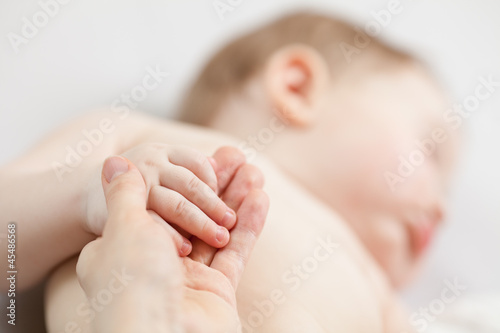 parent's hand holding baby's hand