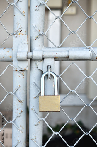 Brass padlock and metal door