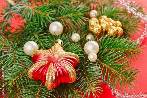 New Year decorations with spruce twig on red background