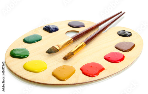 wooden art palette with paint and brushes.isolated on white