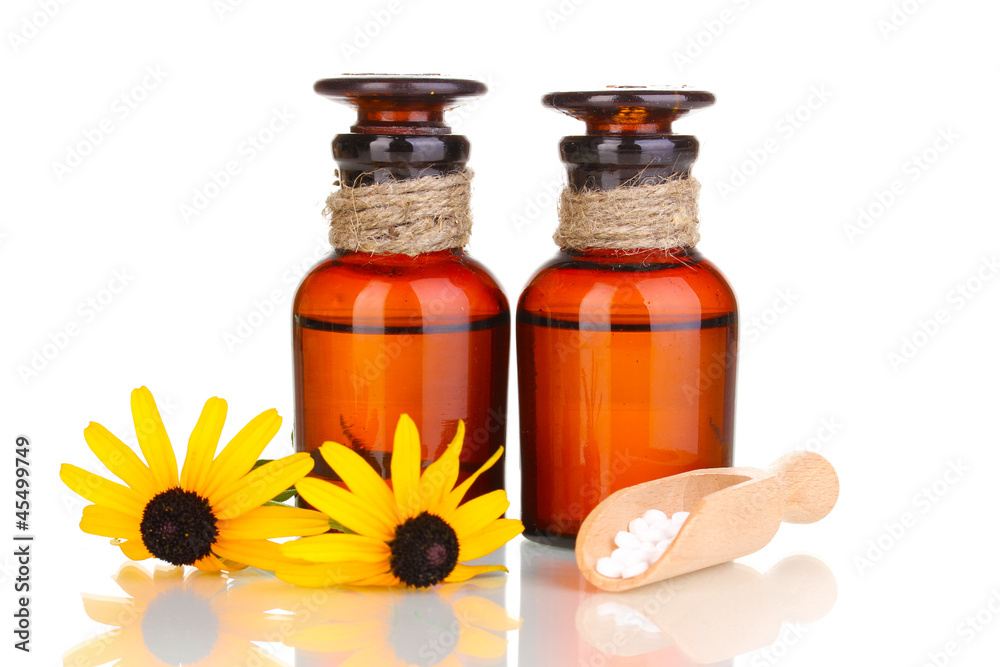 medicine bottles with tablets and flowers isolated on white