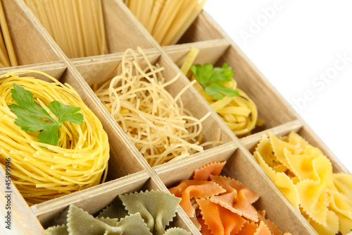 Nine types of pasta in wooden box sections close-up isolated