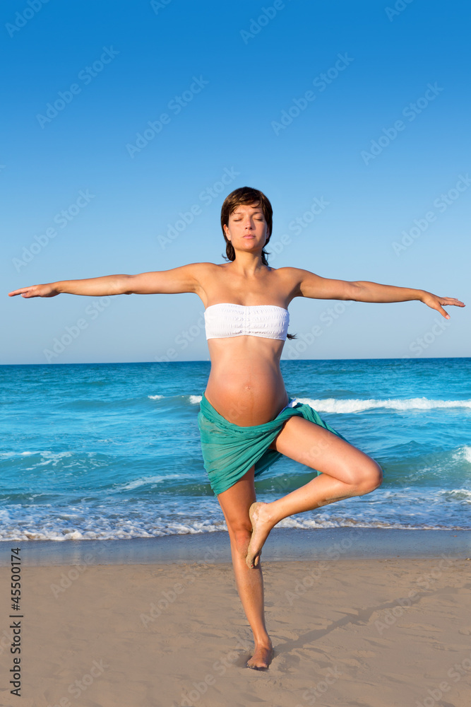 Beautiful pregnant woman precticing yoga in blue beach Beautiful pregnant woman precticing yoga in blue beach