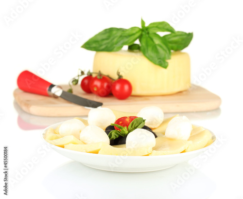 sliced mozzarella cheese with vegetables in the plate isolated