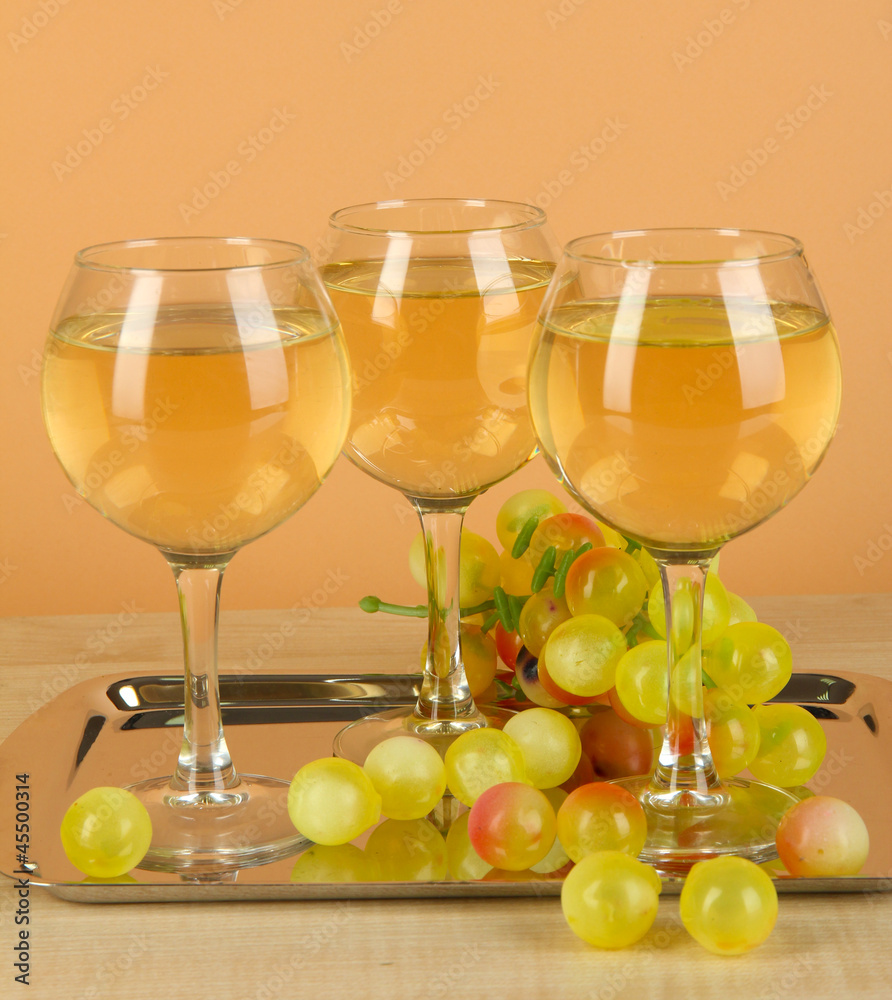 White wine in glass on salver on beige background White wine in glass on salver on beige background