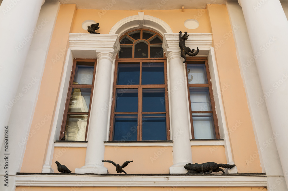 Фасад дома со скульптурами кошек и птиц.