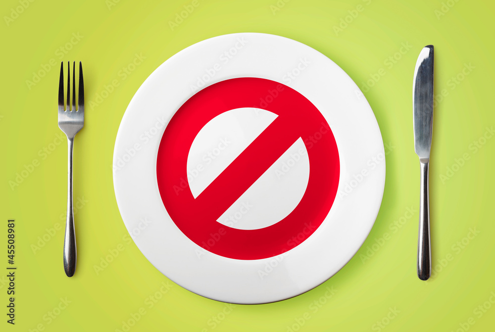 Empty plate with restricted red sign on it - dieting concept im Empty plate with restricted red sign on it - dieting concept im