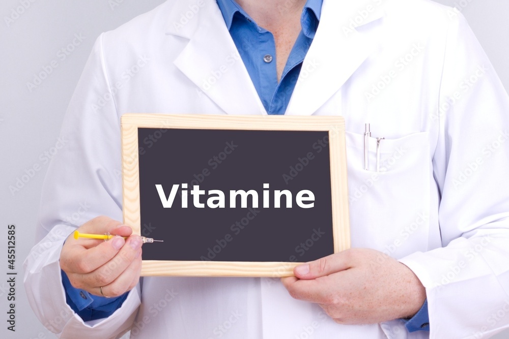 Doctor shows information on blackboard: vitamins Doctor shows information on blackboard: vitamins