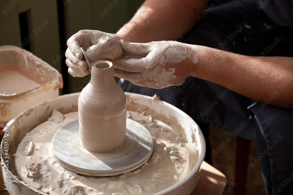 Pottery masterclass. Hands with throwing wheel Pottery masterclass. Hands with throwing wheel